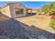 The low maintenance desert backyard features gravel, rock and a small patch of grass at 19904 W Sherman St, Buckeye, AZ 85326