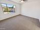 Bright bedroom with a large window, carpet flooring, and a neutral color palette at 19904 W Sherman St, Buckeye, AZ 85326