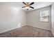 This cozy bedroom features plush carpeting, a ceiling fan, and natural light at 22193 E Via Del Oro --, Queen Creek, AZ 85142