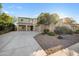 Two-story beige home featuring three-car garage and landscaped front yard under a bright blue sky at 22193 E Via Del Oro --, Queen Creek, AZ 85142