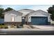 Charming single-story home with blue garage door, stone accents, and low-maintenance desert landscaping at 24405 W Grenadine Rd, Buckeye, AZ 85326