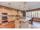 Well-lit kitchen featuring breakfast bar, wood cabinetry, and modern appliances at 279 W Stirrup Ln, San Tan Valley, AZ 85143