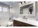Bathroom featuring a tub, walk-in shower, dark wood cabinets, and a framed vanity mirror at 2934 S Woodruff Cir, Mesa, AZ 85212