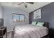 Bedroom featuring a ceiling fan, a window overlooking the neighborhood, and a flat screen TV at 2934 S Woodruff Cir, Mesa, AZ 85212