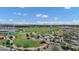 This aerial shot features a community park with a lake, modern play structures, and green fields beneath a blue sky with white clouds at 3010 E Fruitvale Ave, Gilbert, AZ 85297