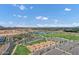 Expansive aerial view showcasing the community park with sports fields, a lake, and a playground under a bright blue sky at 3010 E Fruitvale Ave, Gilbert, AZ 85297