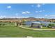Aerial view of a serene lake surrounded by lush green spaces and a modern architectural structure under a clear sky at 3010 E Fruitvale Ave, Gilbert, AZ 85297