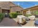 A covered backyard patio with outdoor furniture, a barbecue, brick pavers and greenery at 3010 E Fruitvale Ave, Gilbert, AZ 85297