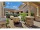 A shaded patio with brick pillars, covered furniture, BBQ grill, and verdant landscaping at 3010 E Fruitvale Ave, Gilbert, AZ 85297