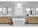 Bright bathroom with double vanities, soaking tub, and modern light fixture at 3010 E Fruitvale Ave, Gilbert, AZ 85297