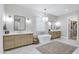 Elegant bathroom featuring double vanities, soaking tub, and walk-in closet entrance at 3010 E Fruitvale Ave, Gilbert, AZ 85297