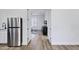 Bedroom with connecting walk through, featuring luxury vinyl plank floors and stainless steel refrigerator at 3010 E Fruitvale Ave, Gilbert, AZ 85297