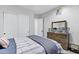Bedroom features carpet floors, a dresser with a mirror, and large closet with double doors at 3010 E Fruitvale Ave, Gilbert, AZ 85297
