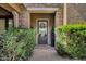 A stone front entrance to a home with green shrubbery and a dark door at 3010 E Fruitvale Ave, Gilbert, AZ 85297