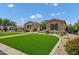 A well manicured front yard with green grass, bushes, and a stone elevation home at 3010 E Fruitvale Ave, Gilbert, AZ 85297