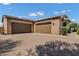 A three car garage featuring brick driveway and tan stucco elevation at 3010 E Fruitvale Ave, Gilbert, AZ 85297
