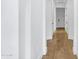 Hallway with pristine white walls, dark doors, and hard wood flooring at 3010 E Fruitvale Ave, Gilbert, AZ 85297