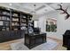 Spacious home office with custom built-in shelving, a large wooden executive desk, and a bright window at 3010 E Fruitvale Ave, Gilbert, AZ 85297