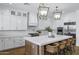 Bright kitchen with a large island, white cabinetry, stainless steel appliances, and decorative pendant lights at 3010 E Fruitvale Ave, Gilbert, AZ 85297