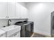 Laundry room featuring modern washer and dryer, and stylish cabinets, along with sink at 3010 E Fruitvale Ave, Gilbert, AZ 85297