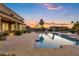 Backyard view of the pool and spa with a water slide, covered patio, and desert landscaping at 3010 E Fruitvale Ave, Gilbert, AZ 85297