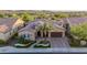 Expansive aerial view of a well-manicured home showcasing landscaping, tile roof, and desert surroundings at 30404 N 131St Dr, Peoria, AZ 85383
