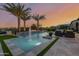 Luxury backyard featuring a modern pool with fountains, lush palm trees, and comfortable seating areas at 30404 N 131St Dr, Peoria, AZ 85383
