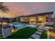 Luxury backyard with a pool, spa, lush landscaping, and open-concept access to the home's interior at 30404 N 131St Dr, Peoria, AZ 85383