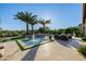 Beautiful backyard with a sparkling pool, a cozy fire pit, and lush landscaping, perfect for outdoor relaxation at 30404 N 131St Dr, Peoria, AZ 85383