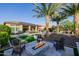 Spacious backyard featuring a fire pit, pool with water feature, palm trees, and outdoor seating area at 30404 N 131St Dr, Peoria, AZ 85383