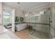 Bright bathroom features a walk-in shower, soaking tub, and bedroom access at 30404 N 131St Dr, Peoria, AZ 85383