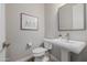 Charming half bath features a pedestal sink, toilet, and framed artwork at 30404 N 131St Dr, Peoria, AZ 85383