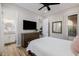 Cozy bedroom featuring neutral decor, a dresser with TV, and views into bathroom and hall at 30404 N 131St Dr, Peoria, AZ 85383