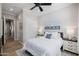 Relaxing bedroom boasts a ceiling fan, two white nightstands, and a view of hallway for added convenience at 30404 N 131St Dr, Peoria, AZ 85383