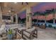 Spacious covered patio with a full kitchen, outdoor seating, and stunning views of the pool and lush landscaping at 30404 N 131St Dr, Peoria, AZ 85383