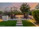 Outdoor seating area with a cozy fire pit and artificial turf and stone landscaping at 30404 N 131St Dr, Peoria, AZ 85383