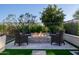 Outdoor living space showcasing a stone fire pit surrounded by comfortable seating in a landscaped backyard at 30404 N 131St Dr, Peoria, AZ 85383