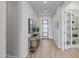 Hallway with wood floors, leading to a front door and an office with built-in shelves at 30404 N 131St Dr, Peoria, AZ 85383