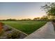 Scenic view of a lush green space with mature trees, vibrant flowers, and a paved pathway, perfect for outdoor enjoyment at 30404 N 131St Dr, Peoria, AZ 85383
