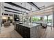 Stylish kitchen with granite island, stainless steel appliances, and open floor plan to living and dining areas at 30404 N 131St Dr, Peoria, AZ 85383