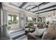 Bright living room with a large sectional sofa, modern lighting, and views of the outdoor pool area at 30404 N 131St Dr, Peoria, AZ 85383