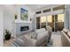 Bright living room with stone fireplace, modern furniture, and sliding glass doors to a private patio at 30404 N 131St Dr, Peoria, AZ 85383