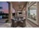 Elegant outdoor patio with a glass table, comfortable seating, and views of the lush backyard at 30404 N 131St Dr, Peoria, AZ 85383