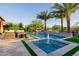Beautiful pool area featuring dual palm trees, a cascading water feature, and travertine pavers at 30404 N 131St Dr, Peoria, AZ 85383
