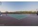 Well-maintained tennis court with a green surface, surrounded by fencing and desert landscaping, offering a private playing experience at 30404 N 131St Dr, Peoria, AZ 85383