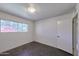 A bedroom with bare concrete flooring, white walls and trim, one window and an overhead light fixture at 325 W Loma Ln, Phoenix, AZ 85021