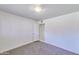 A bedroom with bare concrete flooring, white walls and trim, one closet and an overhead light fixture at 325 W Loma Ln, Phoenix, AZ 85021
