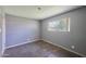 A bedroom with bare concrete flooring, gray walls and trim, and one window at 325 W Loma Ln, Phoenix, AZ 85021