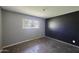 A bedroom with bare concrete flooring, gray and black walls, one window, a power outlet, and no light fixture at 325 W Loma Ln, Phoenix, AZ 85021