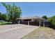 Charming single-story home with a long driveway, mature tree, and gated entrance at 325 W Loma Ln, Phoenix, AZ 85021